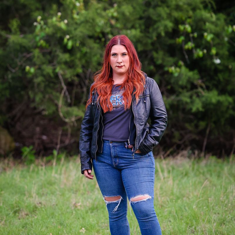 Vocalist in a leather jacket standing in a field
