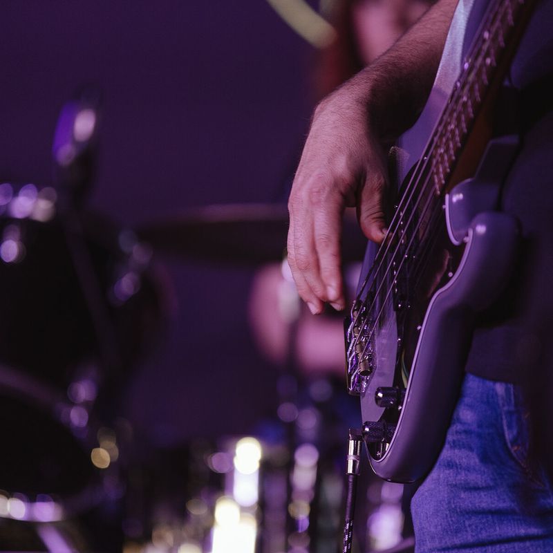 Close-up of a bass guitar under purple stage light